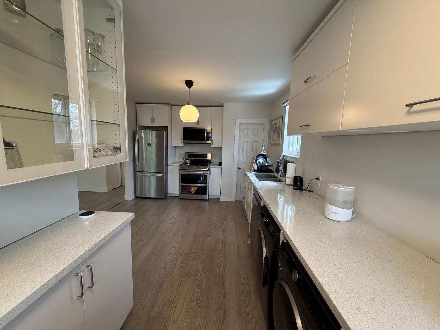 Renovated kitchen and laundry with white cabinets and quartz counters