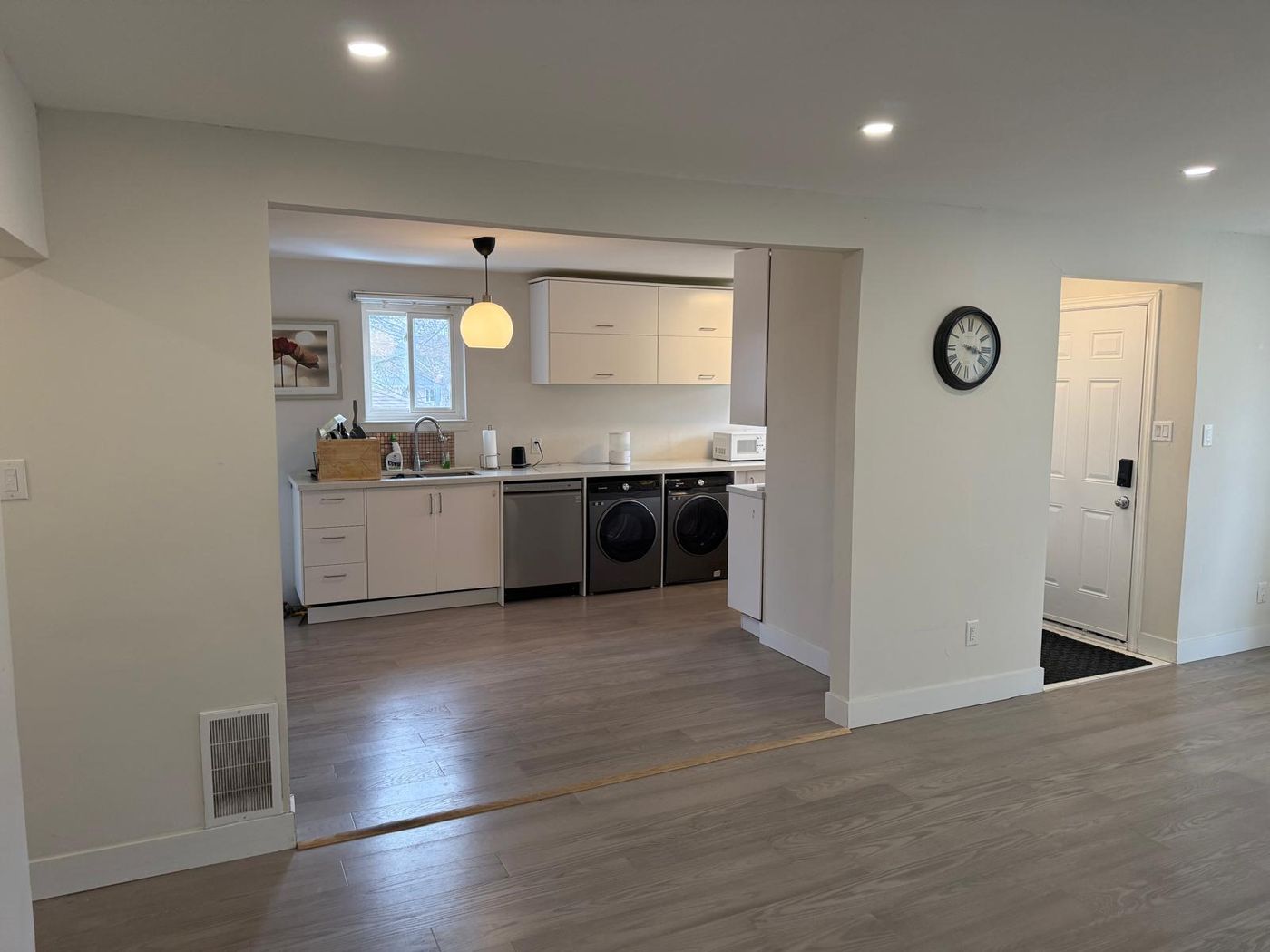 Open-plan main floor with the kitchen visible through a widened opening
