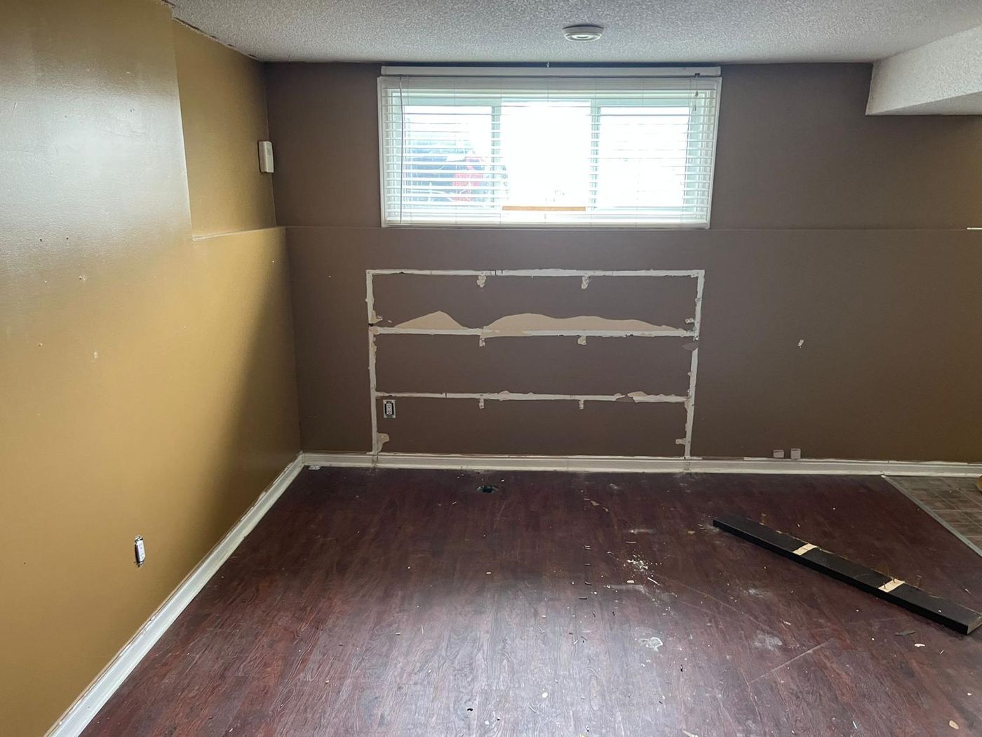 Basement wall with drywall patched flat and ready for paint