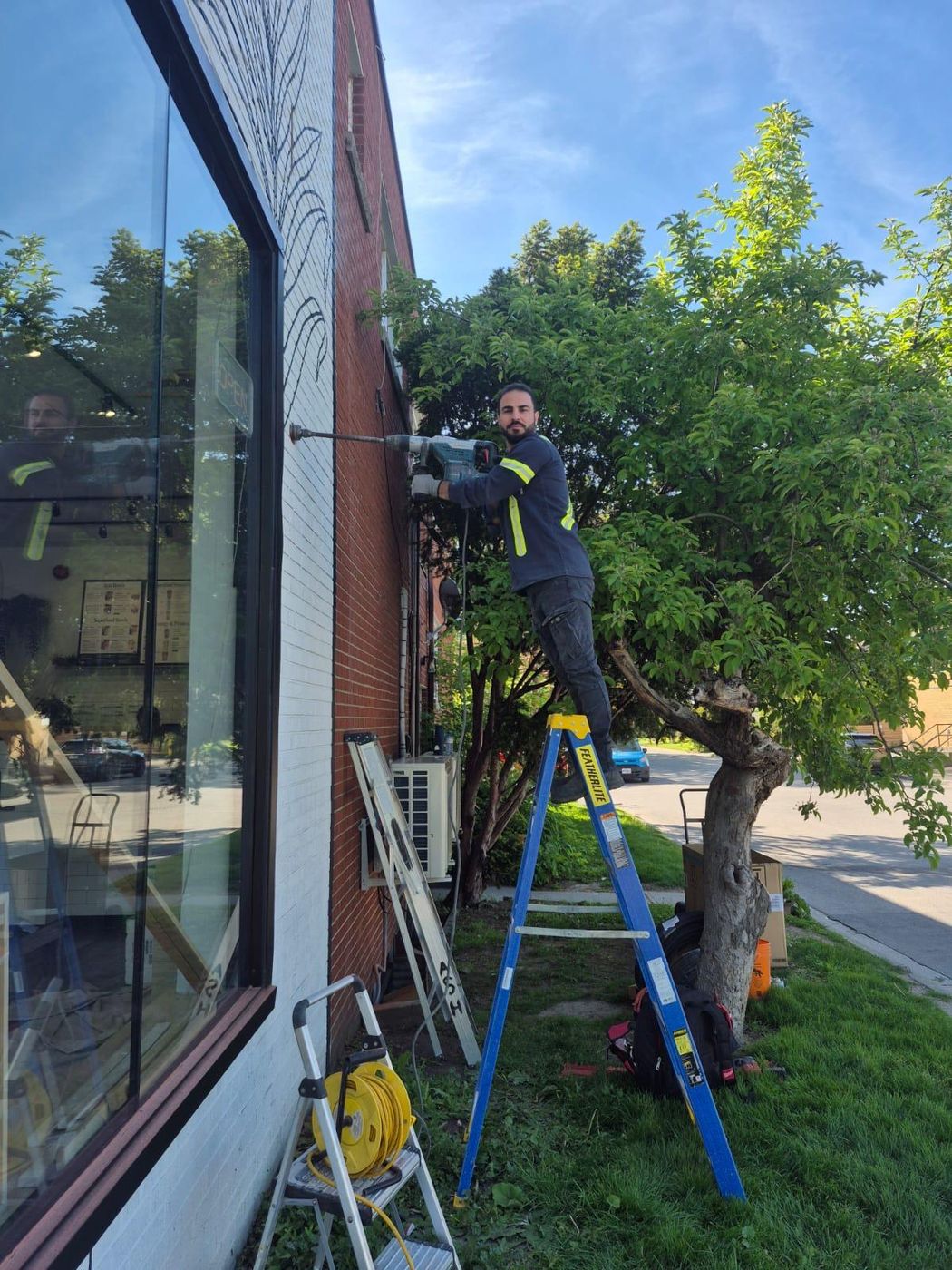 HVAC technician on a ladder installing an exterior unit
