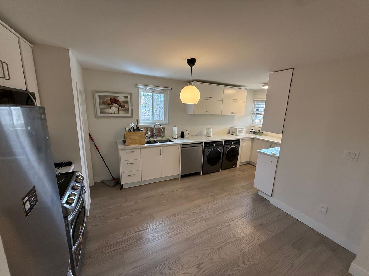 Refitted kitchen with white cabinets and stainless appliances